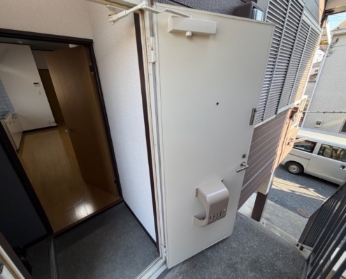 埼玉県幸手市 賃貸アパート 玄関ドアシート張り施工後 ホワイト仕上げ